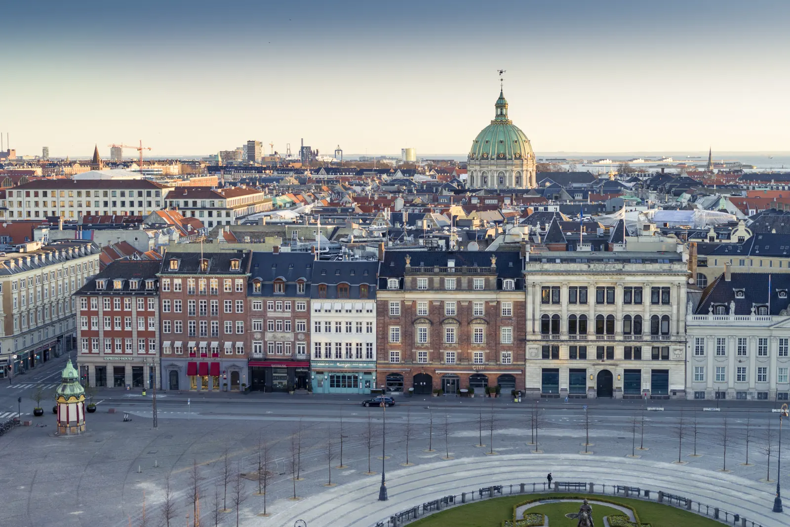 Kongens Nytorv in Copenhagen seen from above, with the dome of Frederik's Church rising behind the rooftops